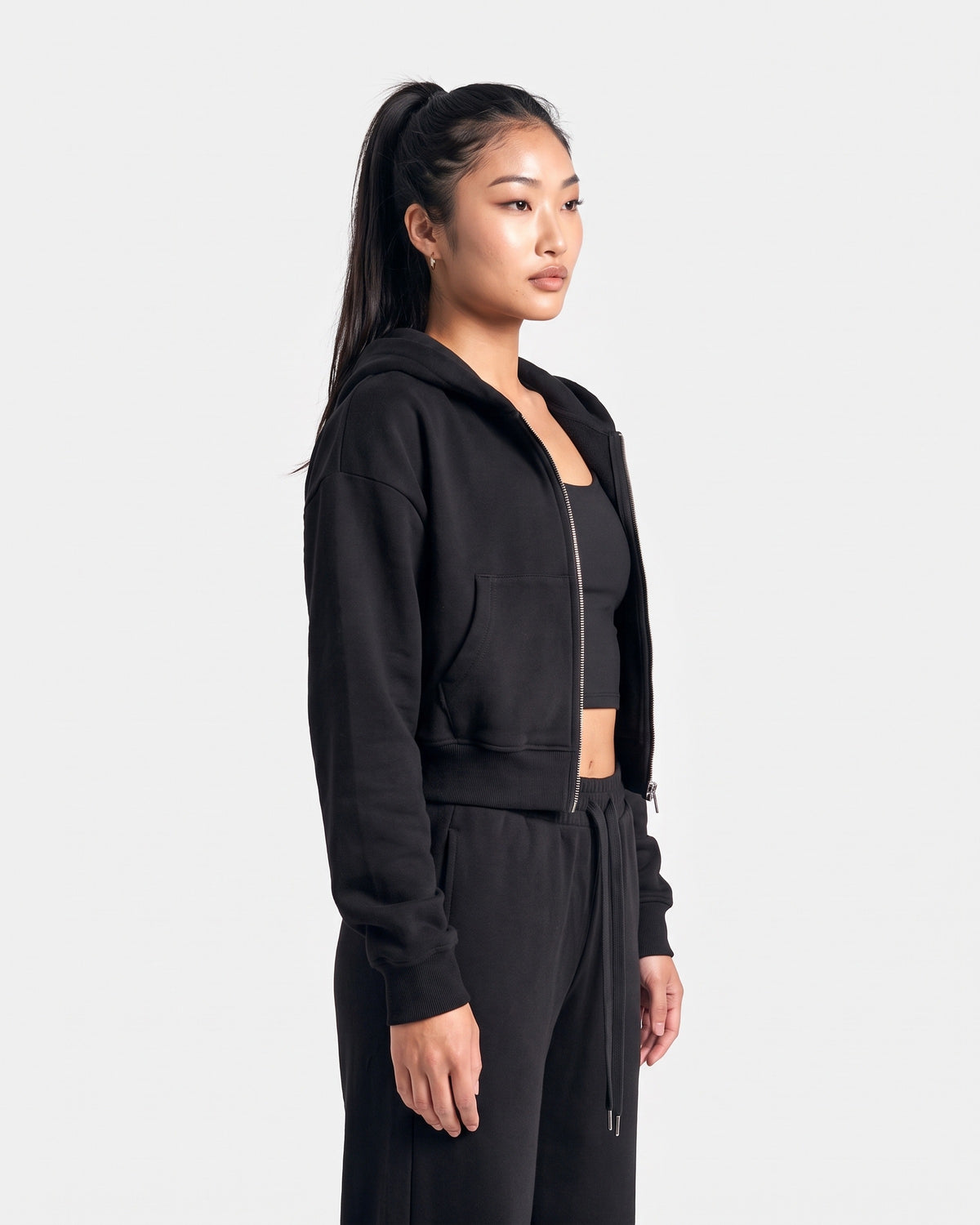 OMNÉA Cropped Zip Hoodie in OMNÉA Black – Dreiviertelansicht