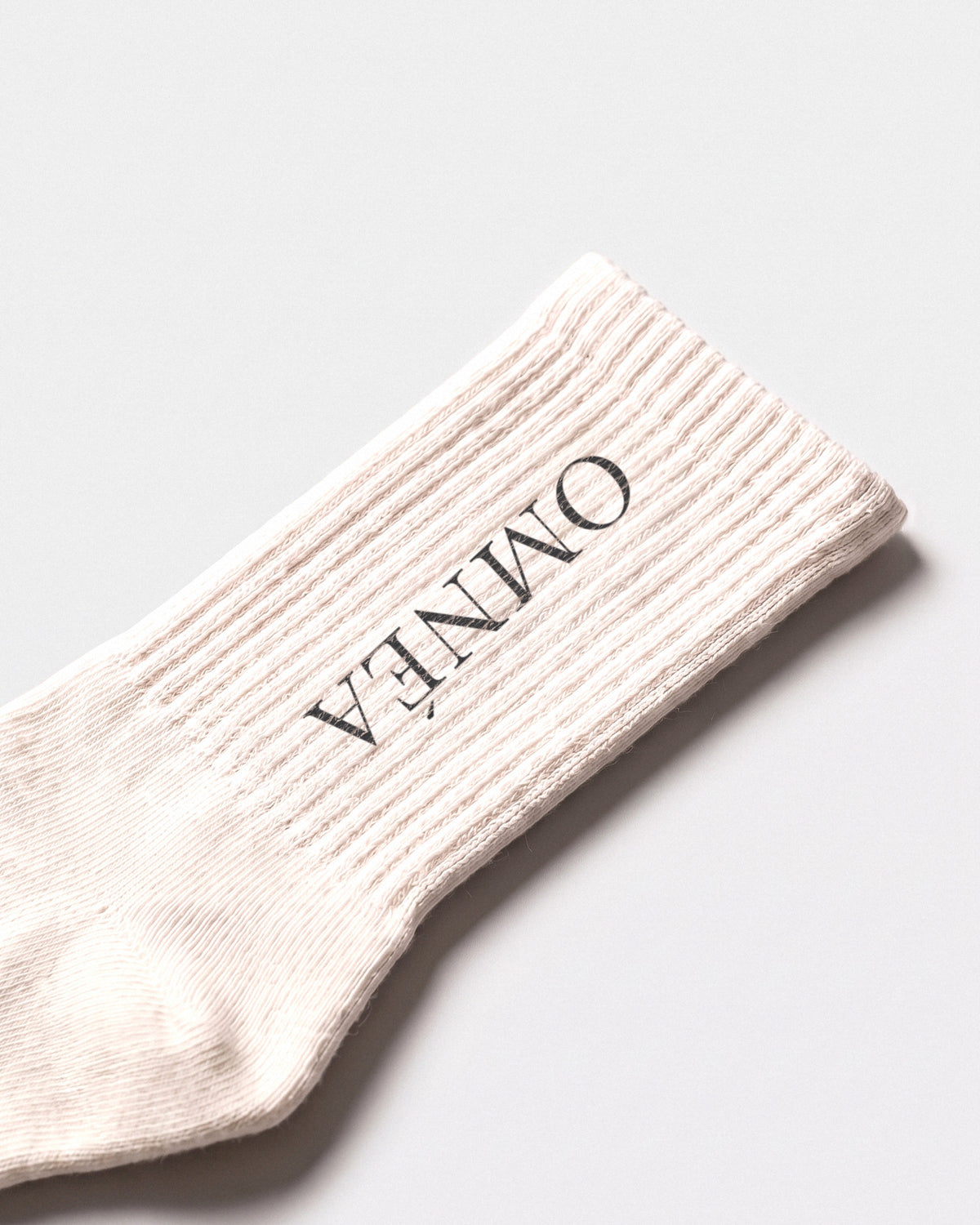 OMNÉA Élite Socks in Ivory – Detail Logo und Strick